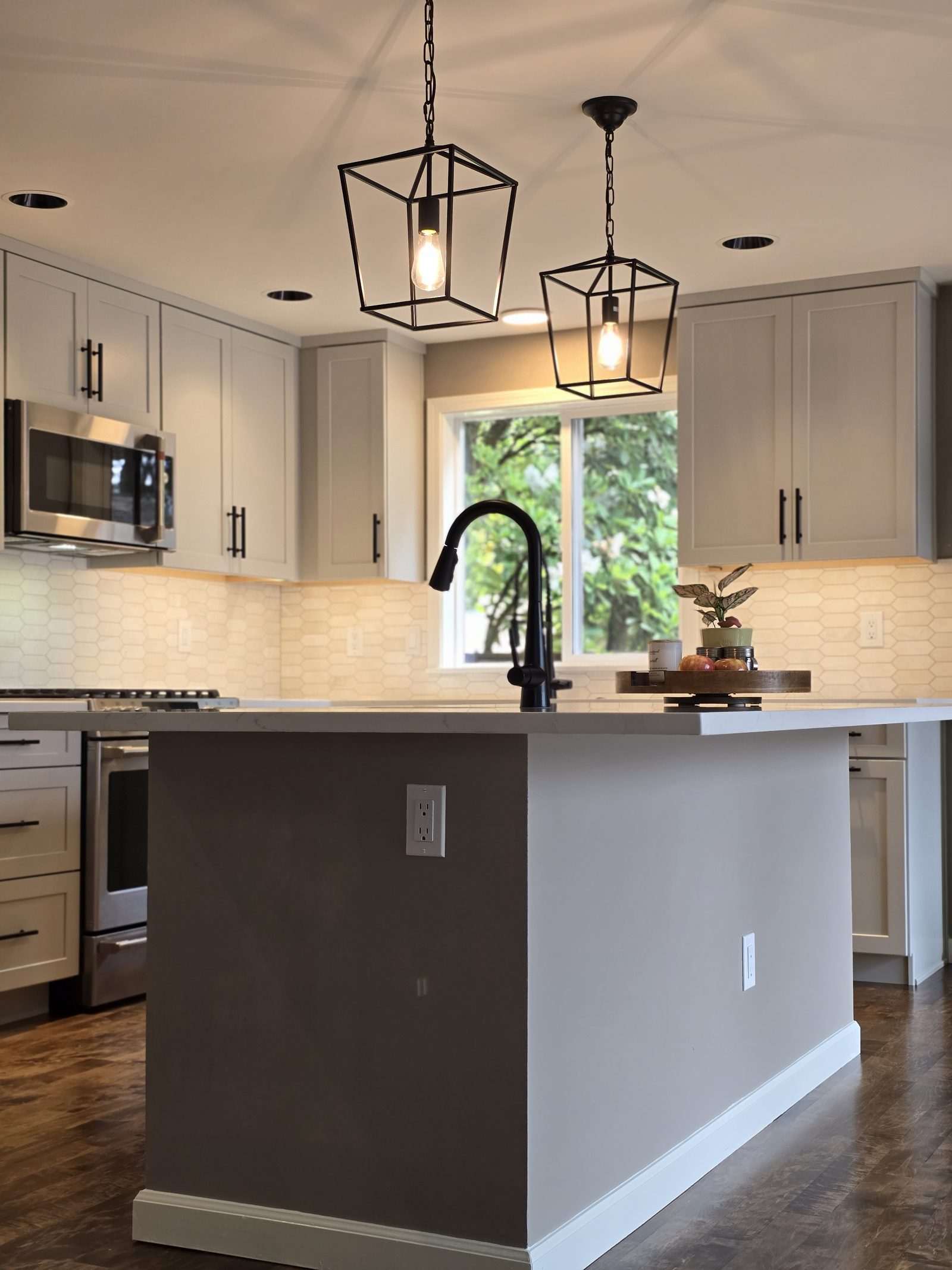 Island with quartz countertop and pendant lights
