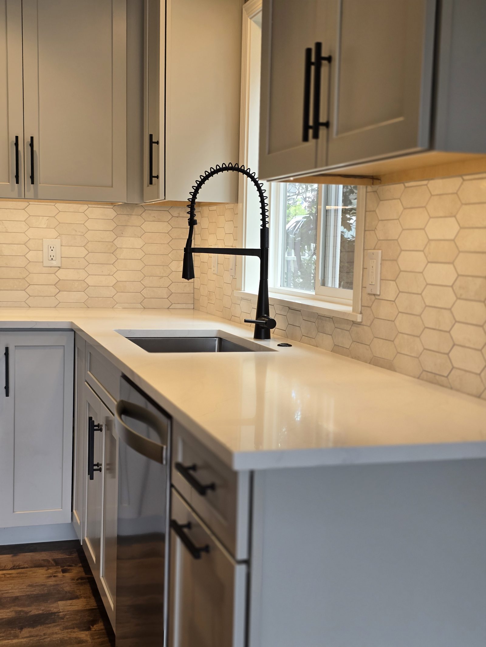 Sink with black faucet and tile backsplash